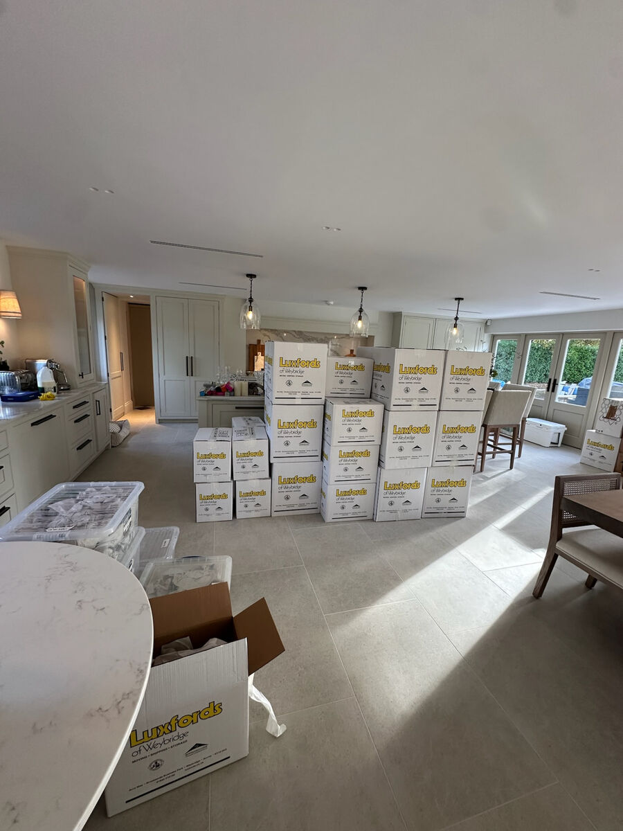 Moving boxes stacked in a bright open-plan kitchen on moving day