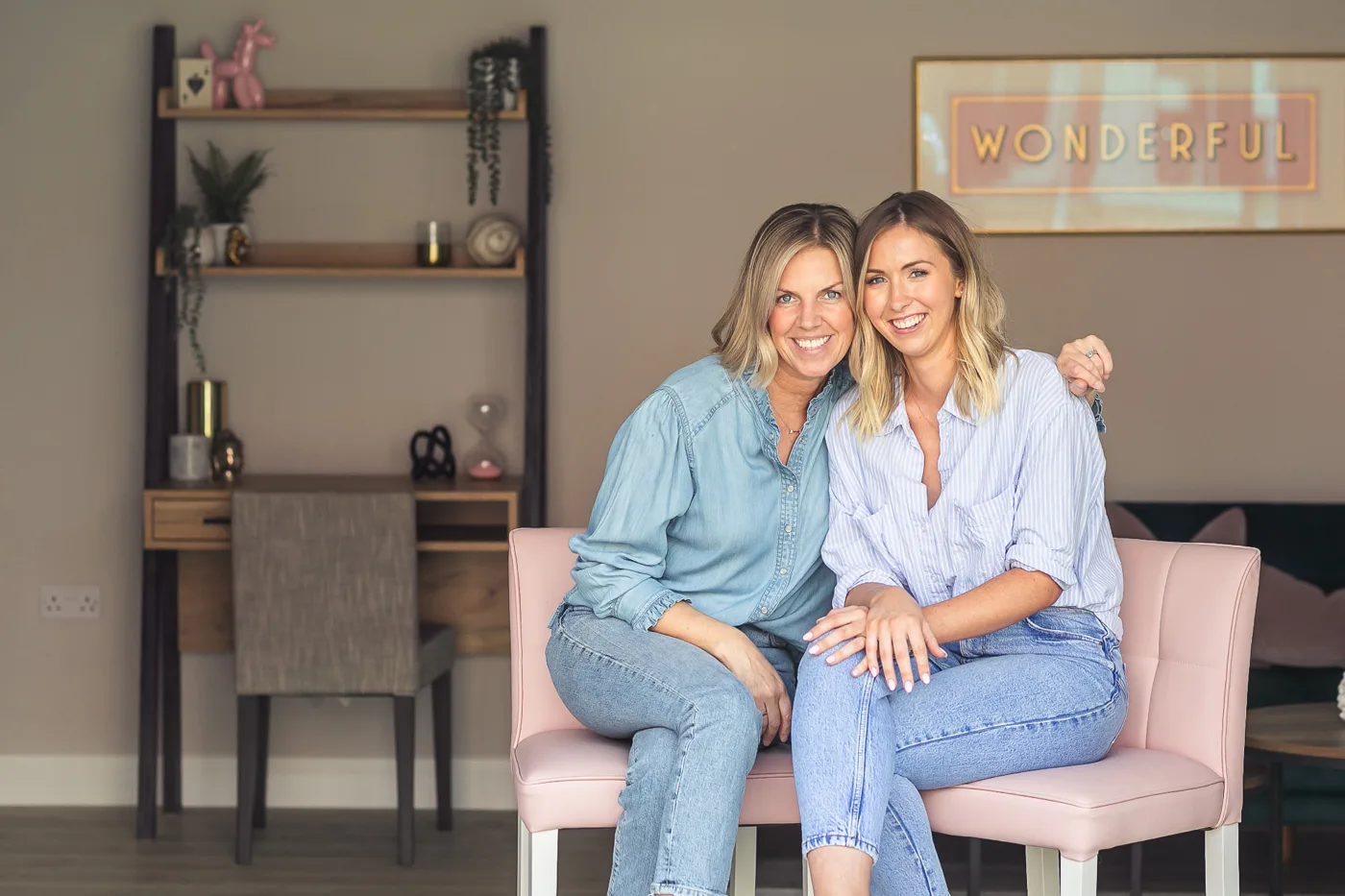Helen and Ruth, the founders of Your Moving Day, smiling together on a pink chair at home
