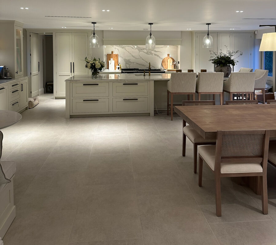The same open-plan kitchen unpacked, with clear worktops, flowers on the island and the dining table set out