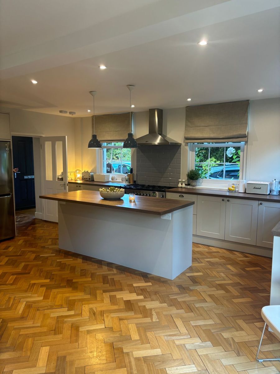 The same Sunningdale kitchen unpacked, with clear worktops, a tidy island and pendant lights on