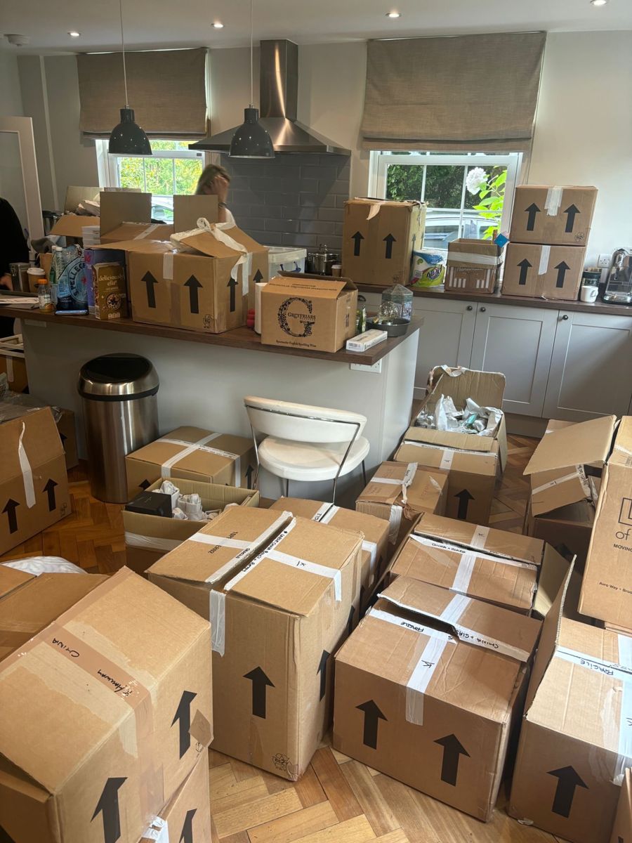 The Sunningdale kitchen on arrival, with moving boxes stacked across the floor and island